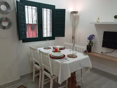 a dining room with a white table and chairs at Casa dos avós in Ribadavia