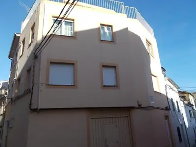 a large white building with a garage at Wanderlust Estudio in Ribadeo