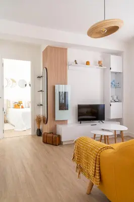 a living room with a yellow couch and a tv at Wanderlust Estudio in Ribadeo