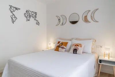 a bedroom with a bed with white sheets and pillows at Wanderlust Estudio in Ribadeo