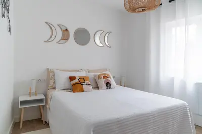 a white bedroom with a white bed with pillows at Wanderlust Estudio in Ribadeo