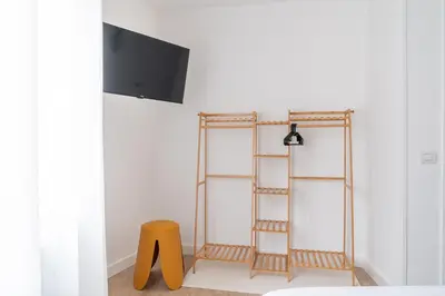 a room with three shelves and a yellow stool at Wanderlust Estudio in Ribadeo
