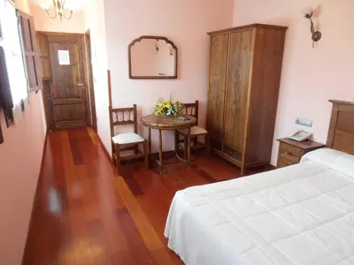 a bedroom with a table and a bed and a mirror at Hostal Virgen de la Encina in Ponferrada