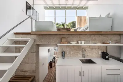 a kitchen with white cabinets and a sink at Casas do Sarela by Upper Luxury Housing in Santiago de Compostela