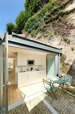 a house with a kitchen and a table on a patio at Casas do Sarela by Upper Luxury Housing in Santiago de Compostela