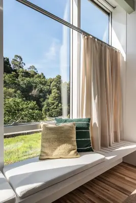 a window seat in a room with a large window at Casas do Sarela by Upper Luxury Housing in Santiago de Compostela