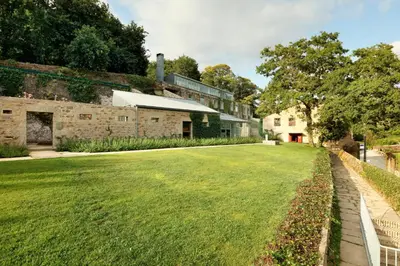 a large grassy yard in front of a building at Casas do Sarela by Upper Luxury Housing in Santiago de Compostela