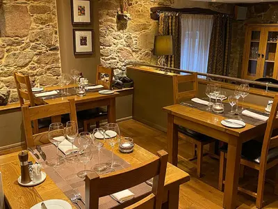 a dining room with tables and chairs with wine glasses at Casa Camino Turismo Rural in Palas de Rei