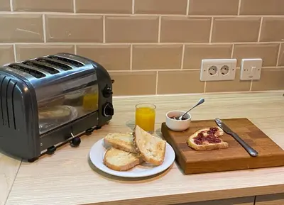 a toaster and toast on a counter with a plate of bread at Casa Camino Turismo Rural in Palas de Rei