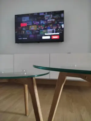 a glass table and a tv on a wall at Casa da Porta -----------------3 dormitorios in Lugo
