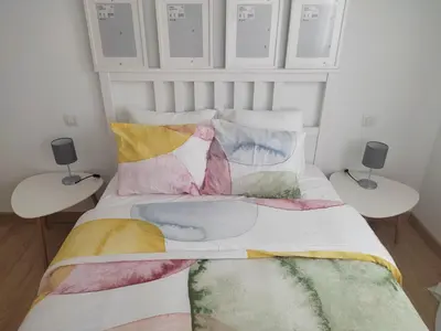 a bed with colorful pillows on it in a room at Casa da Porta -----------------3 dormitorios in Lugo