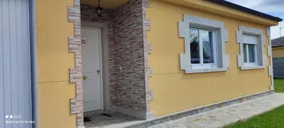 a yellow house with a white door and windows at Casa Da Praia in Lugo