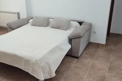 a bed with two pillows and a couch in a room at Casa Da Praia in Lugo