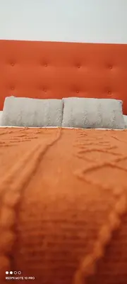 a close up of a bed with orange sheets at Casa Da Praia in Lugo