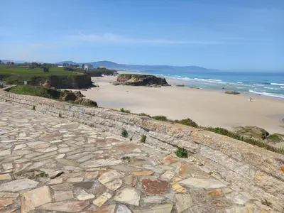 a stone retaining wall next to a beach at Casa Acantilado Barreiros in Barreiros