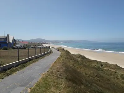 a path along a beach with the ocean in the background at Casa Acantilado Barreiros in Barreiros