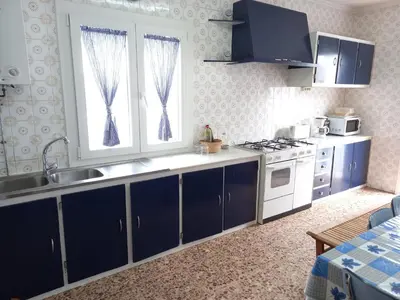 a kitchen with blue cabinets and a sink and a stove at Casa Acantilado Barreiros in Barreiros