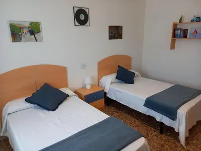 a room with two beds with blue pillows at Casa Acantilado Barreiros in Barreiros