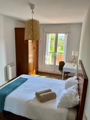 a bedroom with a large bed with two towels on it at EnVIVEIRO Relax Total Playa de Covas in Viveiro