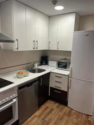a kitchen with white cabinets and a stainless steel refrigerator at EnVIVEIRO Relax Total Playa de Covas in Viveiro