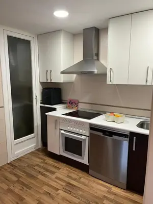a kitchen with white cabinets and a stove top oven at EnVIVEIRO Relax Total Playa de Covas in Viveiro