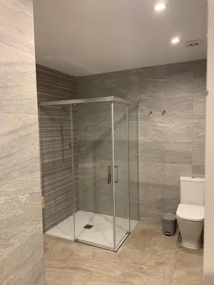 a shower stall in a bathroom with a toilet at Apartamentos Paseo Colón in Foz