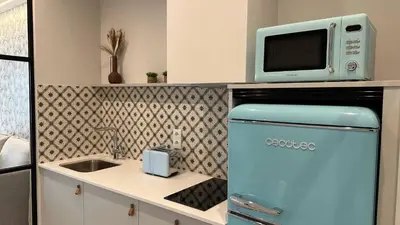 a kitchen with an old refrigerator and a microwave at Apartamentos Paseo Colón in Foz
