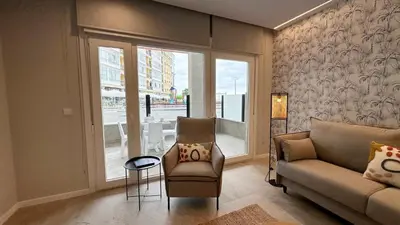 a living room with a couch and a chair and a window at Apartamentos Paseo Colón in Foz