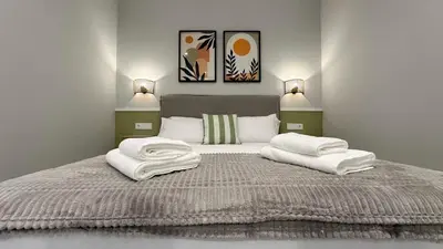 a bedroom with a large bed with towels on it at Apartamentos Paseo Colón in Foz