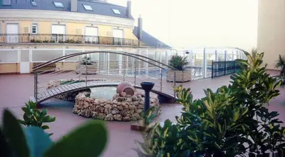 a bridge over a water fountain in front of a building at EnFOZ Con Piscina Parking y Playa a 100 metros in Foz
