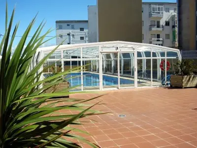 a swimming pool in a glass enclosure next to a building at EnFOZ Con Piscina Parking y Playa a 100 metros in Foz