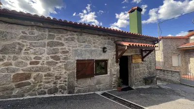 a stone building with a green tower on top at Cozy Galician Stone Farmhouse with Fireplaces and Pool in Santo Tomé