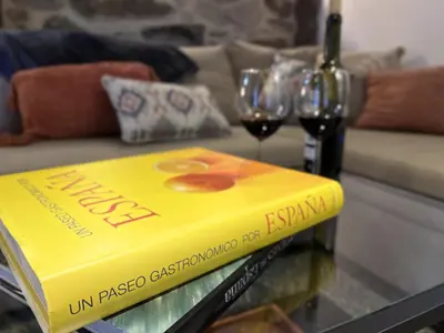 a yellow book sitting on a table with wine glasses at Cozy Galician Stone Farmhouse with Fireplaces and Pool in Santo Tomé
