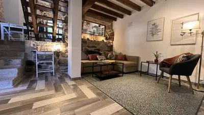 a living room with a couch and a table at Cozy Galician Stone Farmhouse with Fireplaces and Pool in Santo Tomé