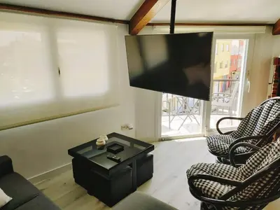 a living room with two chairs and a flat screen tv at Apartamento Llave del Mar in Burela de Cabo