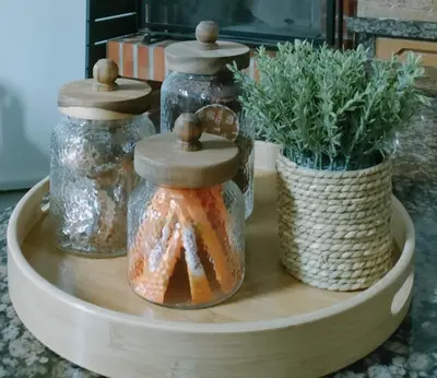 two jars on a wooden tray with a potted plant at Apartamento Llave del Mar in Burela de Cabo