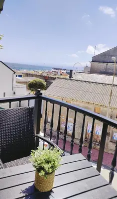 a balcony with a wooden bench and a plant at Apartamento Llave del Mar in Burela de Cabo