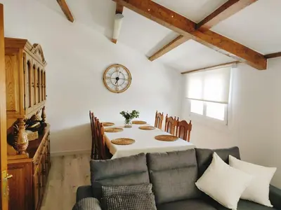 a dining room with a table and a couch at Apartamento Llave del Mar in Burela de Cabo