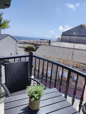 a wooden bench with a plant on a balcony at Apartamento Llave del Mar in Burela de Cabo