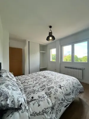 a bedroom with a large bed with a black and white blanket at A de Carmiña in A Coruña