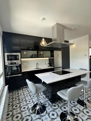 a kitchen with a white counter and chairs in it at A de Carmiña in A Coruña