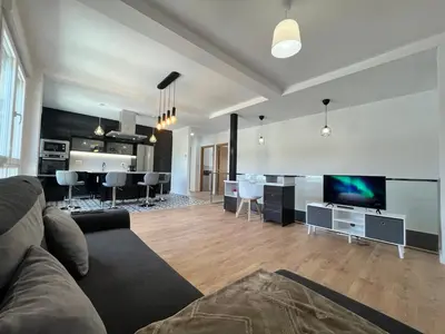 a living room with a couch and a tv and a kitchen at A de Carmiña in A Coruña