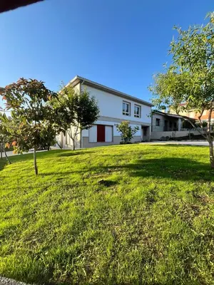 a house with a large yard with trees in front of it at A de Carmiña in A Coruña