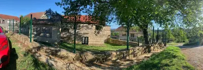 a fence in front of a building behind a house at Casa 1921 in Quinés