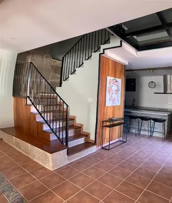 a staircase in a living room with a table at Casa 1921 in Quinés
