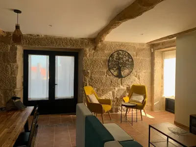 a living room with yellow chairs and a table at Casa 1921 in Quinés