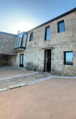 a stone building with a door and a window at Casa 1921 in Quinés