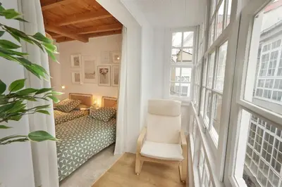 a room with a bed and a chair and a window at Viveiro Dreams in Viveiro
