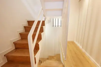 a staircase with white walls and wooden floors at Viveiro Dreams in Viveiro