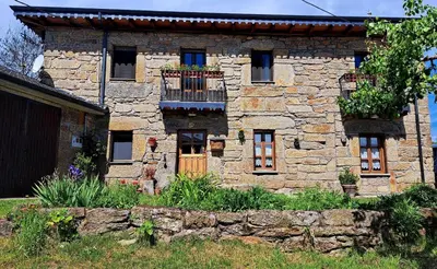 an old stone house with a balcony in a yard at Casa El Filandar in Ríonegrito